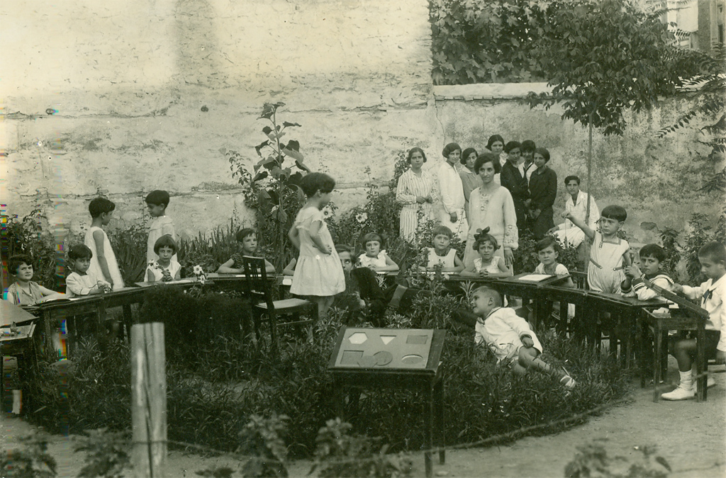 Ομάδα τελειοφοίτων παρακολουθεί τη διήγηση ενός παιδιού της Α' τάξης του Προτύπου της Αλ.Κεσσανλή.